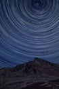 Digital composite image of star trails around Polaris with Epic Peak District Winter landscape of Ramsaw Rocks
