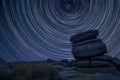 Digital composite image of star trails around Polaris with Stunning landscape image of Higger Tor in Summer in Peak District