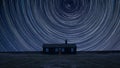 Digital composite image of star trails around Polaris with Vibrant landscape of Remote desolate isolated house