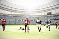 Digital composite image of team of rugby players playing rugby in sports stadium Royalty Free Stock Photo