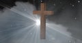 Digital composite image of wooden christian cross against cloud in sky with lens flare at night Royalty Free Stock Photo