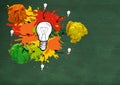 light bulb with colorful crumpled paper balls in front of blackboard Royalty Free Stock Photo