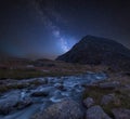 Digital composite Milky Way image of Moody landscape image of river flowing down mountain range near Llyn Ogwen and Llyn Idwal in