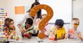 Digital composite of question mark over teacher assisting students in science experiment in class Royalty Free Stock Photo