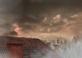 Roof with chimney and city under clouds