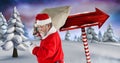 Santa carrying sack and Wooden signpost in Christmas Winter landscape Royalty Free Stock Photo