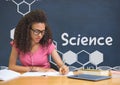 Student girl at table reading against blue blackboard with science text and graphics Royalty Free Stock Photo