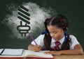 Student girl at table writing against green blackboard with school and education graphic Royalty Free Stock Photo