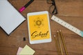 Tablet on a school table with school icons on screen Royalty Free Stock Photo