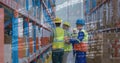 Digital composite of three warehouse workers checking stocks at warehouse Royalty Free Stock Photo