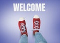 Welcome text and Red shoes on feet with purple background