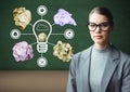 Woman standing next to light bulb with crumpled paper balls in front of blackboard Royalty Free Stock Photo