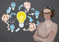 Woman standing next to light bulb with crumpled paper balls in front of blackboard Royalty Free Stock Photo