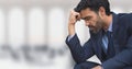 Worried business man sitting against office background Royalty Free Stock Photo