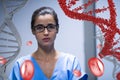 Worried doctor woman standing with 3D DNA strand and cells