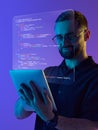 Digital composition. Smiling programmer with digital tablet and holographic code in creative tech workspace Royalty Free Stock Photo