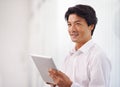 Digital connections in the corporate world. a handsome asian businessman using his digital tablet in the office. Royalty Free Stock Photo