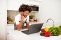 African Man Using Online Cooking Guide On Laptop In Kitchen Royalty Free Stock Photo