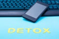 Digital detox concept. Word detox on a smartphone and keyboard background. Gadget addiction Royalty Free Stock Photo