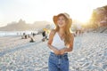 Digital Detox. Smiling young woman on Ipanema beach at sunset, Rio de Janeiro, Brazil. Positive mental health beneficts concept