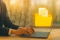 Digital document management concept with glowing folder icons over business laptop keyboard Royalty Free Stock Photo