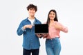 Cheerful Young Students Couple Showing Laptop Empty Screen, Studio Shot Royalty Free Stock Photo