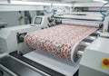 Digital fabric printing machine showcasing vibrant roll-to-roll fabric printing process with colorful patterns, highlighting Royalty Free Stock Photo
