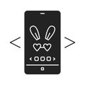 Digital face application black glyph icon. Photo filter bunny ears in smartphone. Pictogram for web page, mobile app, promo. UI UX