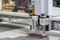 Digital flatbed cutter, plotter cutting white cardboard sheet at exhibition