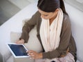 Digital freedom from the comfort of home. A young woman using her digital tablet while sitting at home. Royalty Free Stock Photo