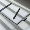 A digital graphics tablet with a stylus is placed on a white surface, partially covered by Royalty Free Stock Photo