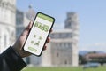 Digital Green Pass concept: Woman hold a smartphone in front of the Pisa leaning tower that show an hypotetical app for the