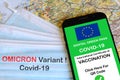 The digital green pass of the European Union with the QR code on the screen of a smartphone and protection masks with text OMICRON Royalty Free Stock Photo