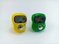 Digital hand tally counter in yellow and green on a white background Royalty Free Stock Photo