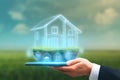 Digital house projection on hand holding smartphone in green field Royalty Free Stock Photo