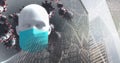 Covid-19 cells and 3D human head model wearing face mask against tall buildings