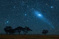 Digital image of  bright comet in the night sky over an open field with trees Royalty Free Stock Photo