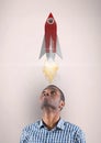 Digital image of man looking up at rocket launch while standing against beige background Royalty Free Stock Photo