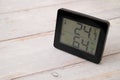 Digital indoor temperature and humidity monitor in a summer on a wooden table