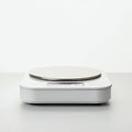 A digital kitchen scale sits on a light gray surface. It features a sleek, compact design Royalty Free Stock Photo