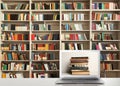 Digital library. Modern laptop on table and shelves with books indoors