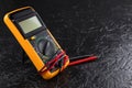Digital multi-meter with probes on a black stone background. Multitester. Voltage Tester. Copy space. Voltmeter Royalty Free Stock Photo