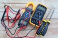 Digital multimeter, clamp-on meter with probes, electrical measuring instruments, and screwdrivers isolated on wooden background Royalty Free Stock Photo