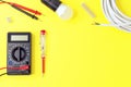 Digital multimeter and indicator screwdriver on a yellow background. Voltmeter, ohmmeter, ammeter Royalty Free Stock Photo