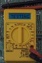 Digital multimeter multitester on a circuit board with the word testing Royalty Free Stock Photo