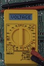 Digital multimeter multitester on a circuit board with the word voltage Royalty Free Stock Photo