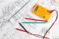 Digital multimeter and pencils on paper electrical engineering drawings