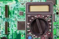 Digital multimeter on a printed circuit board closeup Royalty Free Stock Photo