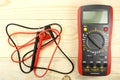 Digital multimeter with probes on a wooden table Royalty Free Stock Photo