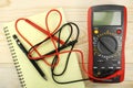 Digital multimeter with probes on a wooden table Royalty Free Stock Photo